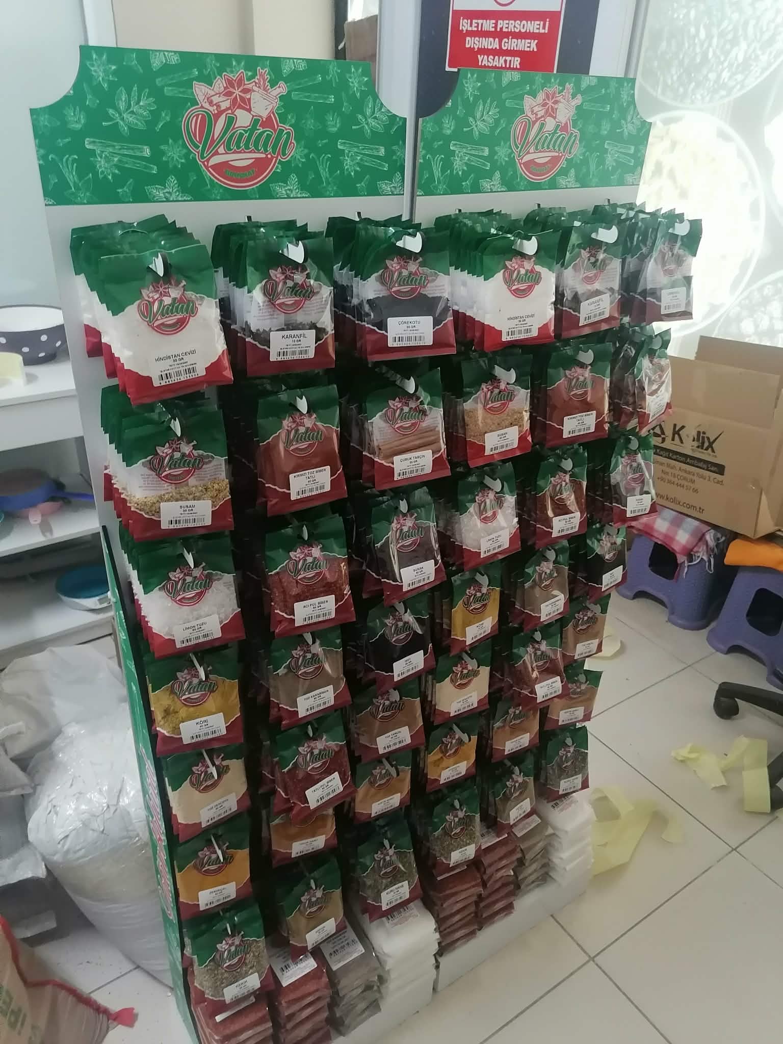 Vatan Baharat üretim standı — şeffaf ambalajlı karabiber, kimyon, pul biber ve zerdeçal paketleri